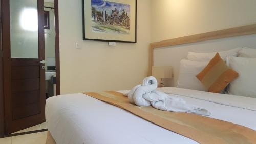 a hotel room with a bed with a towel on it at Nyaman Guest House in Sanur