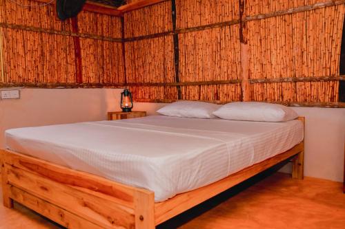 sypialnia z łóżkiem w słomkowym pokoju w obiekcie Sandy Edge w mieście Kalpitiya