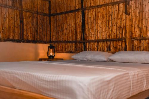 a bed with two pillows on it in a room at Sandy Edge in Kalpitiya