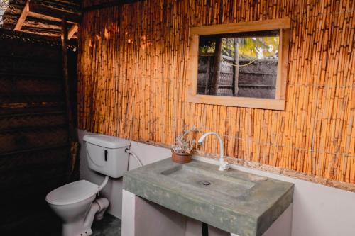 a bathroom with a sink and a toilet and a window at Sandy Edge in Kalpitiya