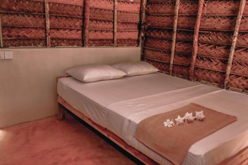 a bed with white sheets and white pillows on it at Sandy Edge in Kalpitiya