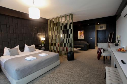 1 dormitorio con 1 cama y sala de estar en Hotel Orhideea, en Negreşti-Oaş
