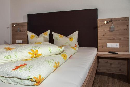a bed with white sheets and flowers on it at Apart Bergland in Kaunertal
