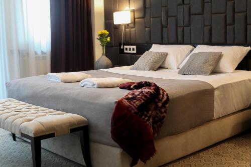 a hotel room with a large bed and a chair at Hotel Orhideea in Negreşti-Oaş