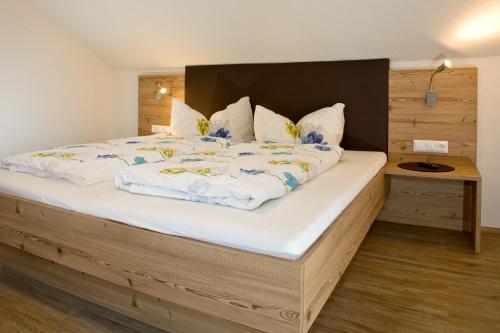 a bedroom with a large bed with a wooden headboard at Apart Bergland in Kaunertal