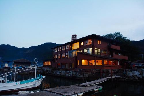 a large building with a boat in the water at Owase Seaside View in Owase