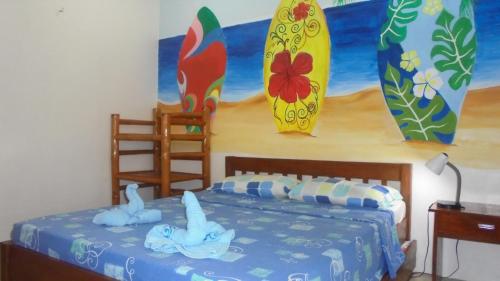 a bedroom with a bed and surfboards on the wall at BLU MA RE GUESTHOUSE - Sugar Beach in Sipalay