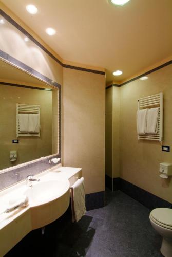 a bathroom with a sink and a toilet and a mirror at Grand Eurhotel in Montesilvano