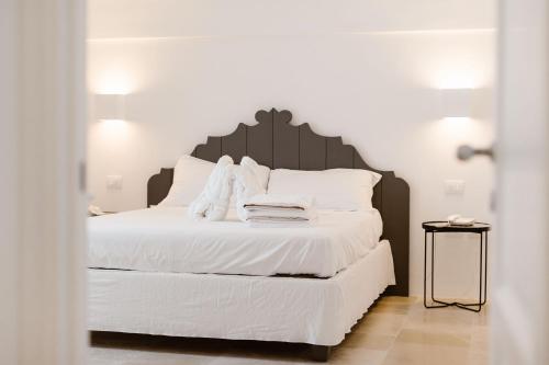 a bedroom with a bed with white sheets and pillows at Giovì Relais in Polignano a Mare