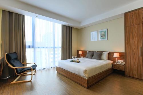 una habitación de hotel con una cama y una silla en Aurora Serviced Apartments, en Ho Chi Minh