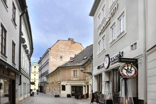 a street with a clock on the side of a building at APLEND CITY Hotel Perugia in Bratislava