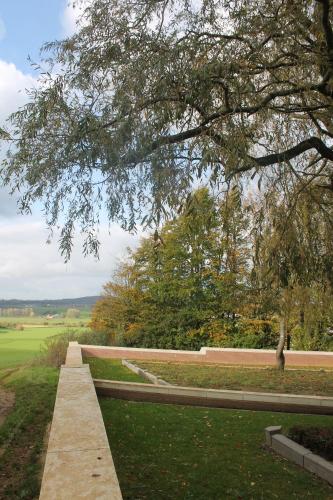 a walkway in a park with a tree at Purple Papillon in Heuvelland