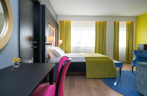 a hotel room with a bed and a table and chairs at Thon Hotel Arendal in Arendal