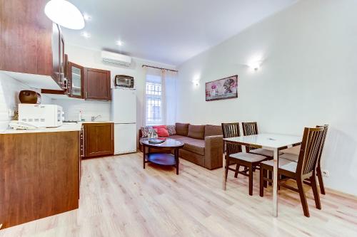 a kitchen and a living room with a table and a couch at Apartments ERS Moika in Saint Petersburg