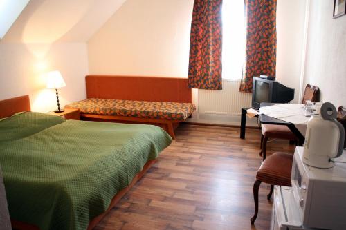 a room with a bed and a table and a television at Kremenisko II in Banská Štiavnica