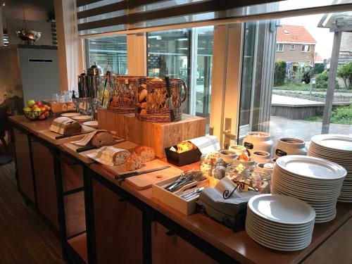 a buffet with plates and food on a table at Vlierijck in Oost-Vlieland