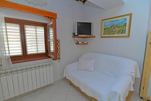 a room with a couch and a television in it at Roberto 3 in Veli Lošinj