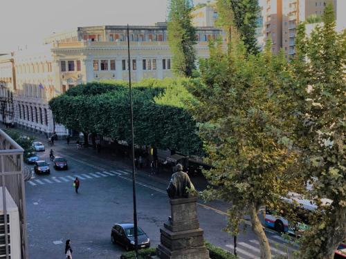 a statue in the middle of a street with a building at Hotel Etnea Royal Suites in Catania