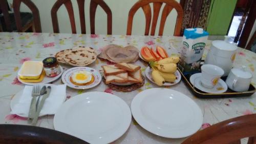 un tavolo con piatti bianchi e cibo sopra di Gem Villa a Weligama