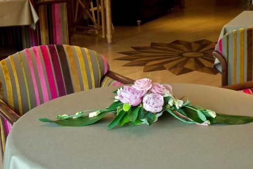 a bouquet of pink flowers sitting on a table at Hotel Les Remparts in Kaysersberg