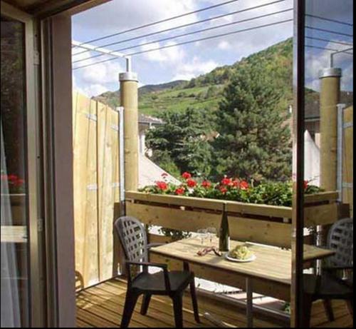 a table and chairs on a balcony with a view at Hotel Les Remparts in Kaysersberg