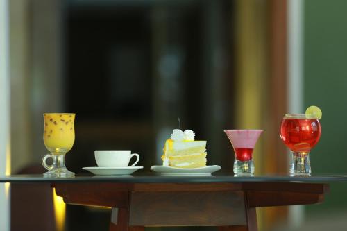 a table topped with a piece of cake and two glasses at Bhasuri Inn Guruvayoor in Guruvāyūr