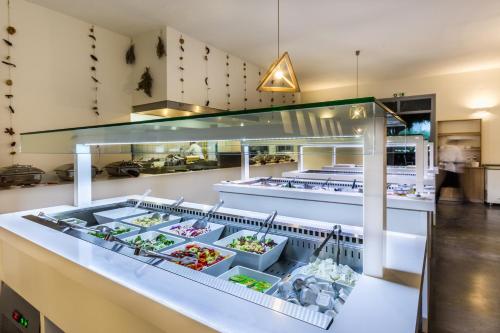 a kitchen with a buffet of food on a counter at Vasia Ormos Hotel (Adults Only) in Agios Nikolaos