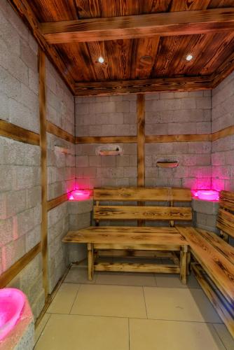 a room with wooden benches and pink lights at Prónay-kastély in Alsópetény
