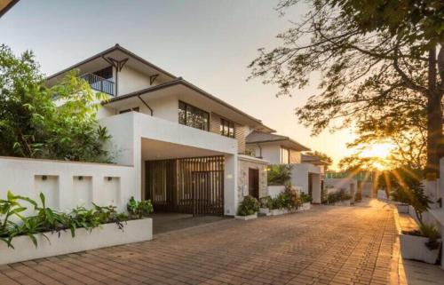 uma casa com uma entrada de tijolos em frente em Frangipani Villa em Anjuna