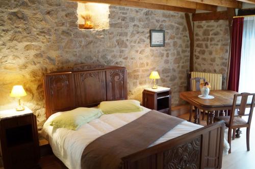 a bedroom with a bed and a table and chairs at Gîte de 15 places en chambre de 2, 4, 5 personnes in Saint-Exupéry-les-Roches