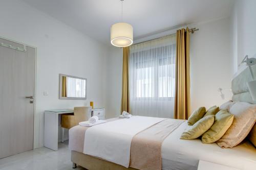 a white bedroom with a large bed with yellow pillows at Villa Blue Panorama in Budva