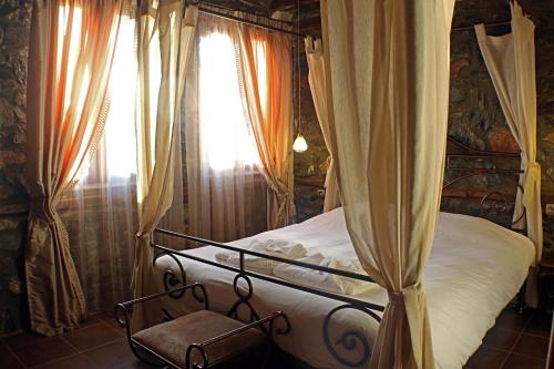 sypialnia z łóżkiem i oknem z zasłonami w obiekcie Zeidoro w mieście Palaios Agios Athanasios