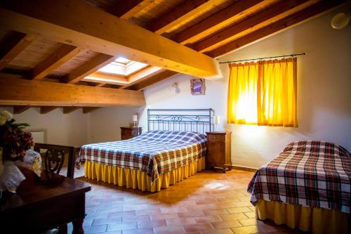 1 dormitorio con 2 camas en una habitación con techos de madera en Agriturismo Bosco Del Gal, en Castelnuovo del Garda