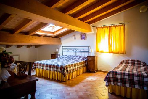 a bedroom with two beds in a room with wooden ceilings at Agriturismo Bosco Del Gal in Castelnuovo del Garda