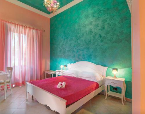a bedroom with a bed with a pink and green wall at Raffaello Residence in Sassoferrato