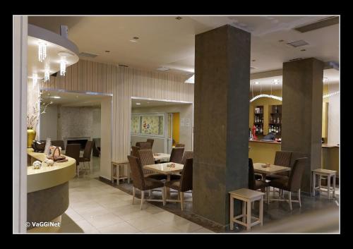 a restaurant with tables and chairs and a bar at Lidra Hotel in Aridaia