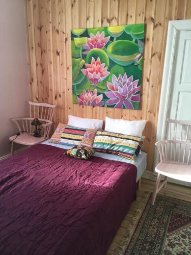 a bedroom with a purple bed and two chairs at Parkgatan villa in Krylbo