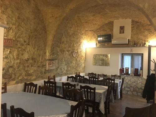 a restaurant with tables and chairs in a stone wall at Tenuta Ferrara in Altavilla Silentina