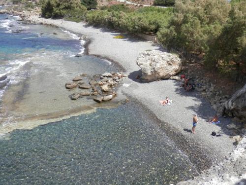 a group of people on a beach near the water at Ravdoucha Beach Studios in Ravdhoúkha
