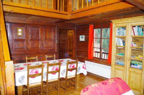 une salle à manger avec une table et des chaises dans une maison dans l'établissement Chalet BETHEL, à Manigod