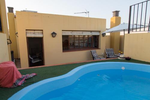 a swimming pool in front of a house at Casa Rural Migolla in Osuna