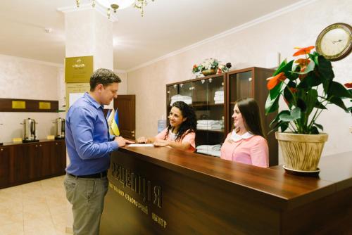 a man standing at a counter in a waiting room at Svityaz Resort in Truskavets