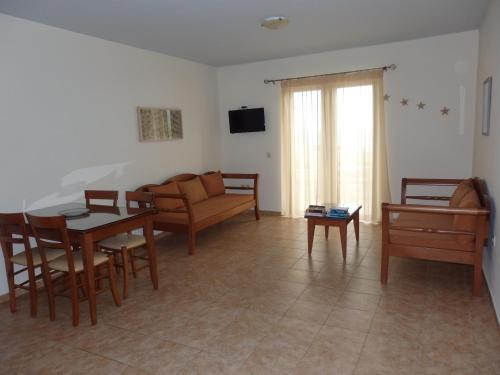a living room with a couch and a table and chairs at Ravdoucha Beach Studios in Ravdhoúkha
