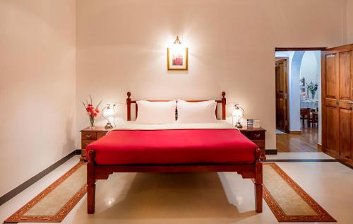 a bedroom with a large bed with a red blanket at Fairy Glen in Coonoor