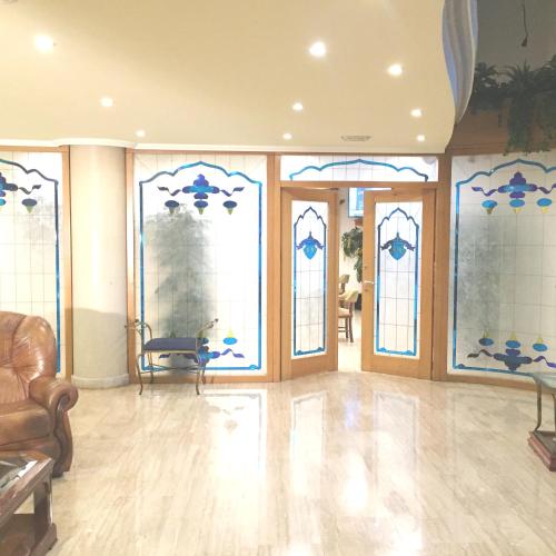a room with stained glass windows and a lobby at Hotel Nueva Plaza in Maliaño