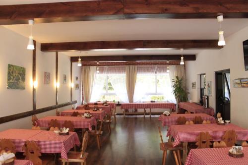 a restaurant with red and white tables and chairs at OW Wisan in Baligród