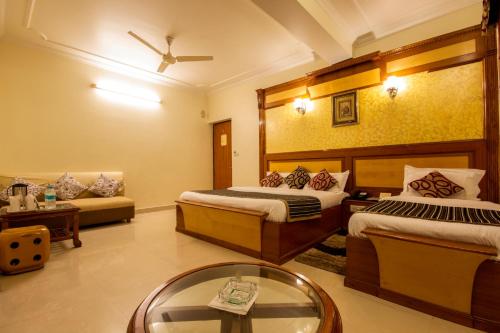 a hotel room with two beds and a table at The C Park Inn Karol Bagh Homely Atmosphere in New Delhi