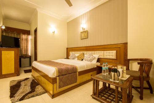 a bedroom with a bed and a table with a telephone at The C Park Inn Karol Bagh Homely Atmosphere in New Delhi