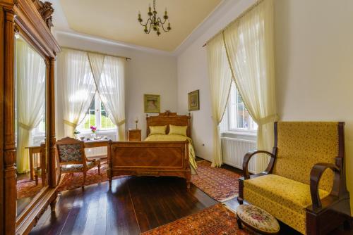 a bedroom with a bed and a desk and a chair at Prónay-kastély in Alsópetény