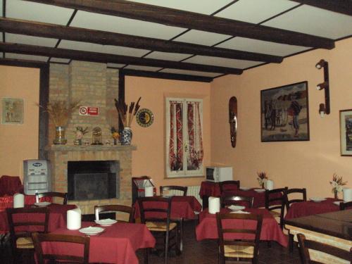 a restaurant with tables and chairs and a fireplace at Albergo Airone in Ostellato
